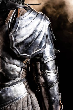 cropped view of knight in armor on black background  clipart