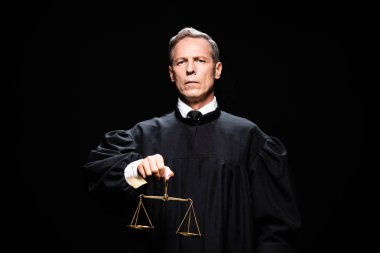 judge in judicial robe holding scales of justice isolated on black  clipart