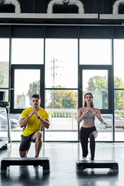 Yakışıklı sporcu ve sporcu kadın spor merkezinde hamle yapıyor.
