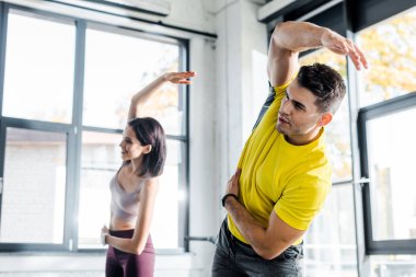 Sporcu ve sporcu kadın spor merkezinde birlikte çalışıyor.