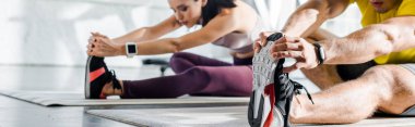 Sporcu ve sporcunun spor merkezindeki spor minderleri üzerinde esnediği panoramik bir çekim.