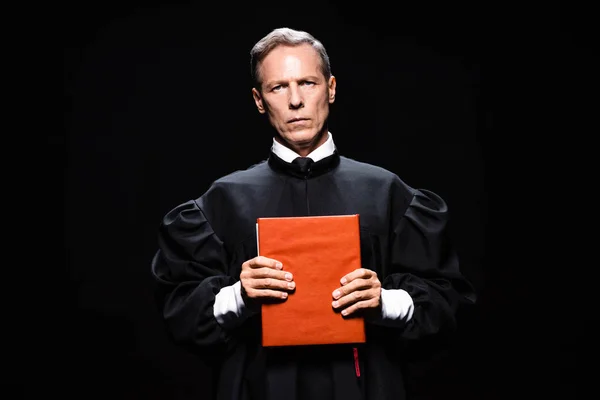 Judge Judicial Robe Holding Orange Book Isolated Black — Stock Photo, Image