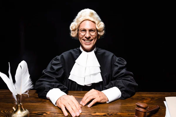 Sonriente Juez Bata Judicial Peluca Sentado Mesa Aislado Negro — Foto de Stock