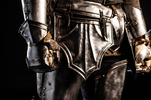 Cropped view of knight in armor isolated on black