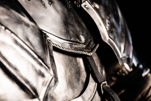 Cropped view of knight in armor isolated on black