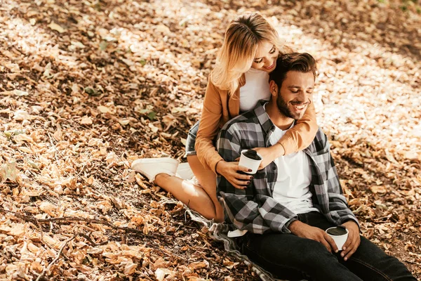 Glückliches Mädchen Umarmt Fröhlichen Freund Während Auf Herbstlaub Park Sitzt — Stockfoto
