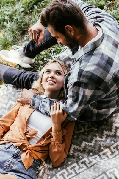 Shora Pohled Mladého Muže Sedí Blízko Usmívající Přítelkyně Ležící Přikrývce — Stock fotografie