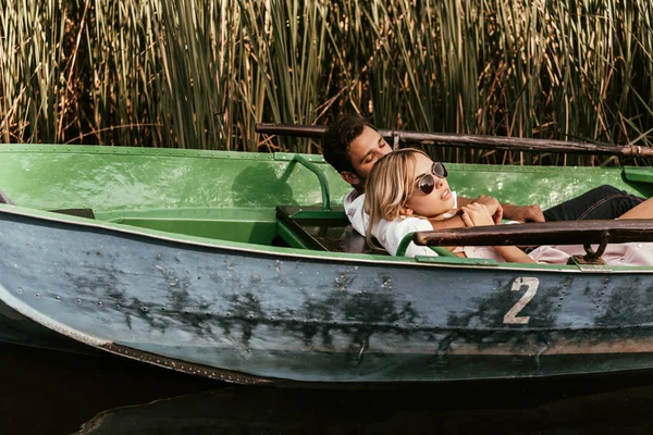若いカップルがセッジの茂みの近くの川でボートでリラックスして — ストック写真