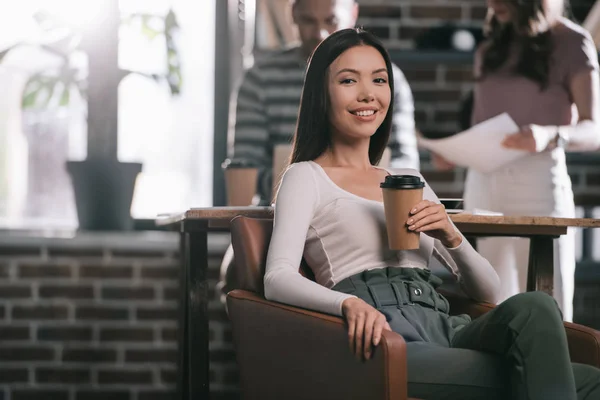Νεαρή Επιχειρηματίας Κάθεται Στην Πολυθρόνα Καφέ Για Πάει Και Χαμογελώντας — Φωτογραφία Αρχείου