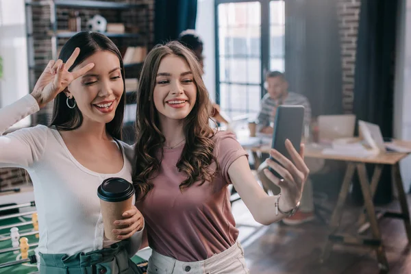 Młoda Wesoła Bizneswoman Robi Selfie Smartfonie Wesołym Kolegą Trzymając Kawę — Zdjęcie stockowe