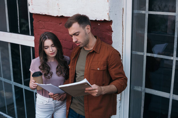 вдумчивый бизнесмен показывает документы внимательному коллеге, беря кофе на вынос
 