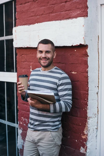 Genç Neşeli Adamı Elinde Belgeler Kahve Tutarken Kameraya Bakıyor — Stok fotoğraf