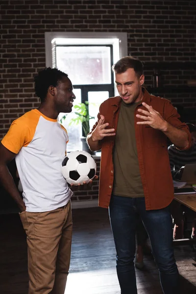 Emocionado Hombre Negocios Gesticulando Mientras Habla Con Colega Afroamericano Sosteniendo —  Fotos de Stock