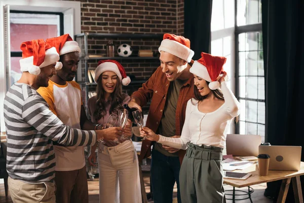 Cheerful Multicultural Businesspeople Santa Hats Clinking Champagne Glasses Office — Stock Photo, Image
