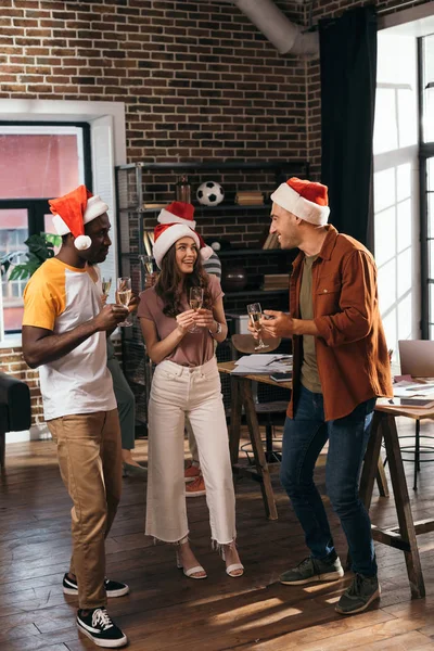 Alegres Empresarios Multiculturales Sombreros Santa Claus Hablando Mientras Sostienen Copas — Foto de Stock