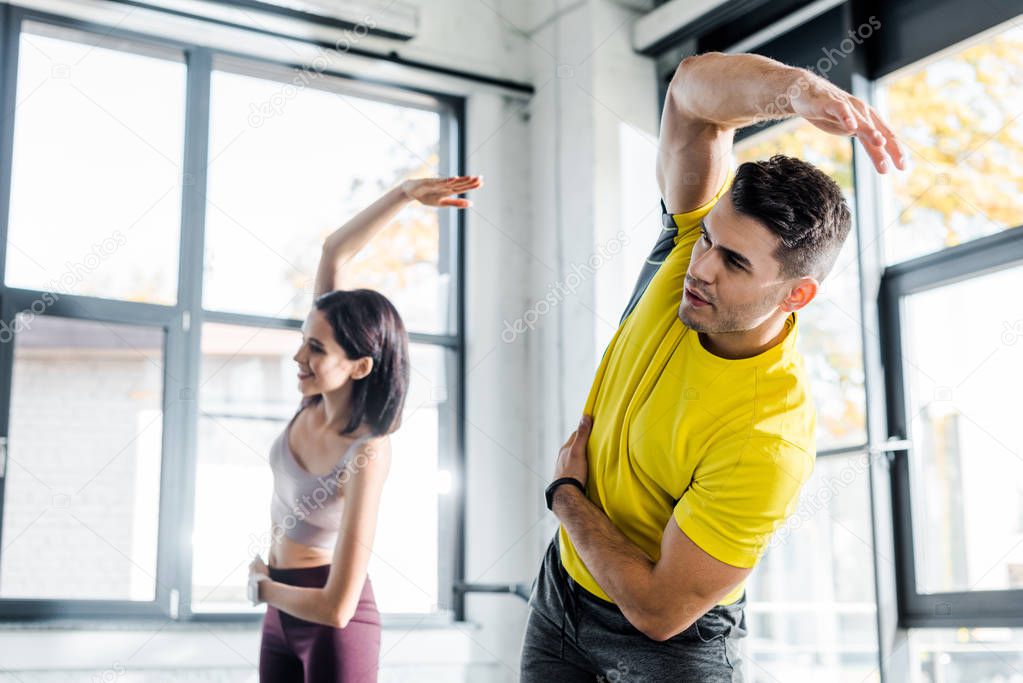 sportsman and sportswoman working out together in sports center