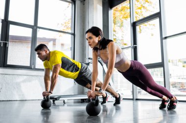 Sporcu ve sporcu kadın spor merkezinde ağırlık kaldırıyor.