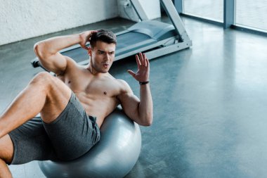 Spor merkezinde spor topu üzerine mekik çeken yakışıklı bir sporcu. 