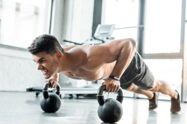 Yakışıklı sporcu spor merkezinde ağırlık kaldırıyor. 