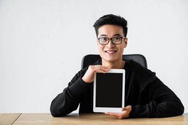 gülümseyen Asyalı hacker dijital tableti kopyalama alanı ile tutuyor