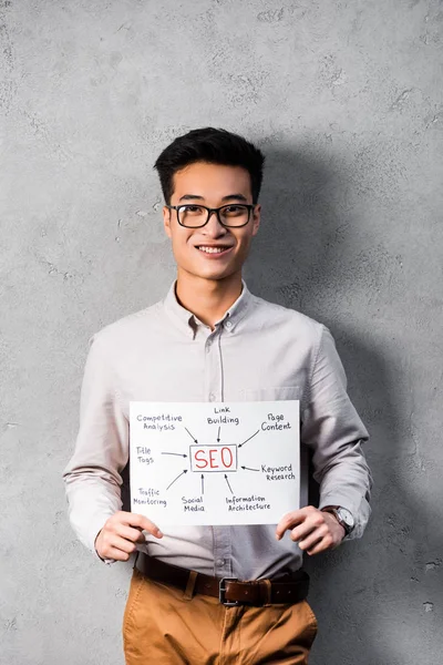 Smiling Asian Seo Manager Holding Paper Concept Words Seo — Stock Photo, Image