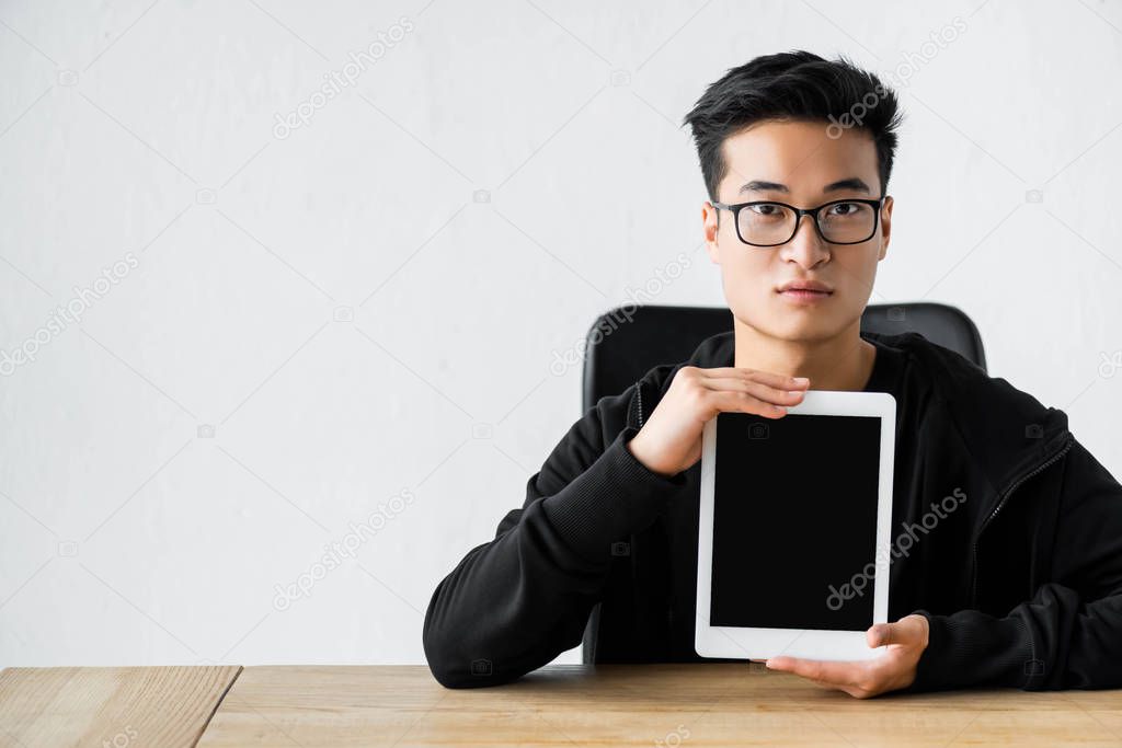 asian hacker holding digital tablet with copy space