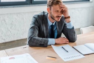 sad businessman with closed eyes near paper and credit card  clipart