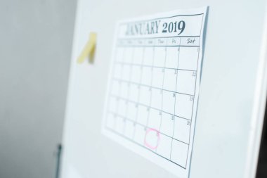 selective focus of calendar with january lettering on flipboard  clipart