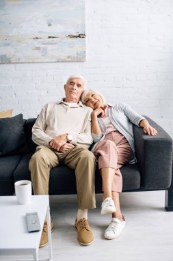 Karı koca kanepede oturup evdeki kanepeyi izliyorlar. 