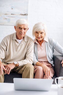 Koca ve gülümseyen eş dairede dizüstü bilgisayara bakıyor. 