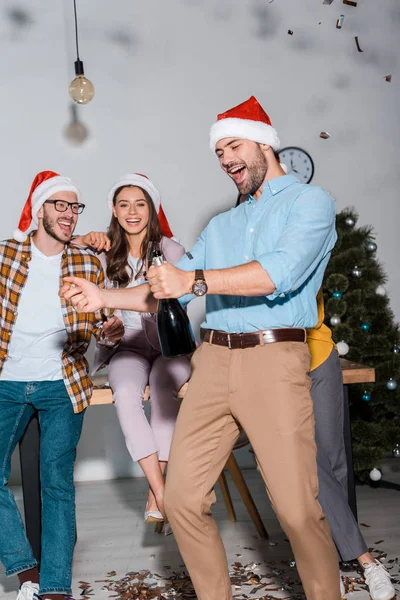 Feliz Hombre Negocios Sombrero Santa Celebración Botella Champán Cerca Compañeros — Foto de Stock