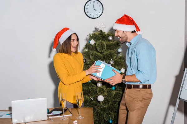 Happy Bearded Businessman Giving Present Asian Businesswoman Santa Hat — Stock Photo, Image