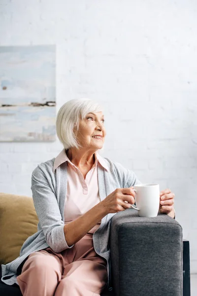 Smiling Senior Woman Sitting Sofa Holding Cup Apartment — Stock Photo, Image