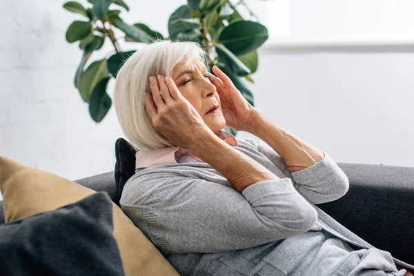 Seniorin Hat Kopfschmerzen Und Sitzt Auf Sofa Wohnung — Stockfoto