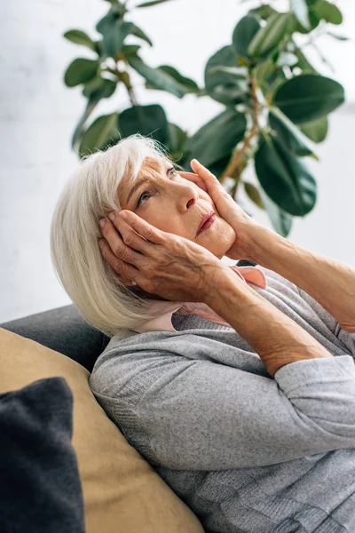 Starszy Kobieta Mając Ból Głowy Siedzi Kanapie Mieszkaniu — Zdjęcie stockowe