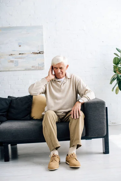 Senior Man Sitting Sofa Having Headache Apartment — стоковое фото