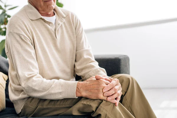 Pandangan Terpotong Dari Orang Senior Duduk Sofa Dan Memiliki Lutut — Stok Foto