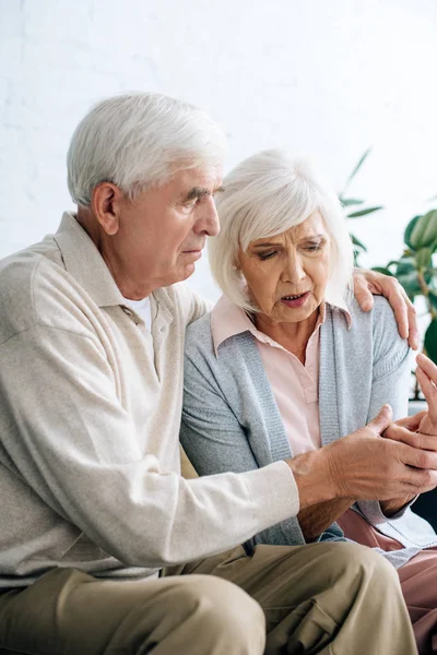 Husband Hugging Looking Wife Pain Hand Apartment — Stock Photo, Image