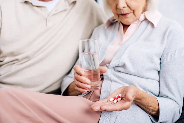 Cropped View Husband Wife Holding Glass Pills Apartment — Stock Photo, Image