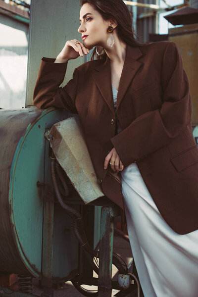 elegant beauty posing in silk dress and brown jacket on roof