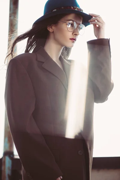 穿着礼帽 眼镜和棕色夹克的优雅时髦女人站在屋顶上 — 图库照片