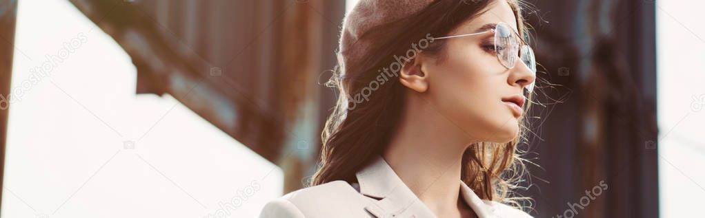 attractive stylish woman posing in beige suit and beret on roof