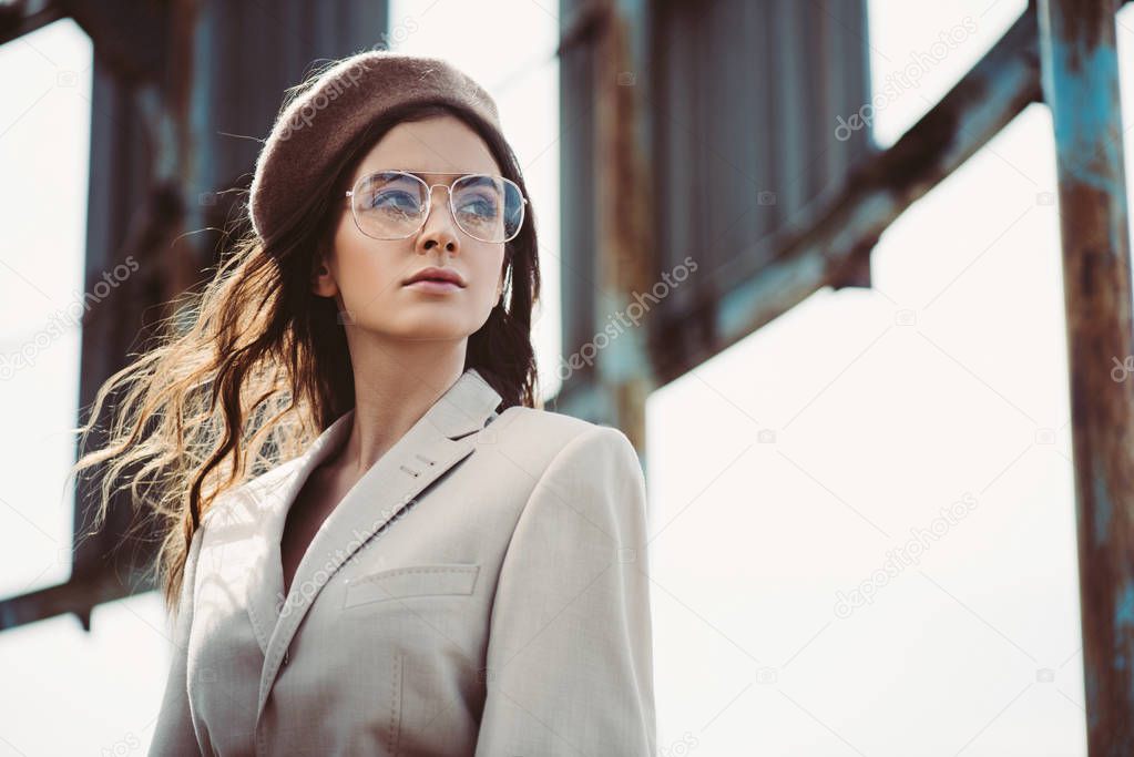 attractive woman posing in beige suit and trendy beret on roof
