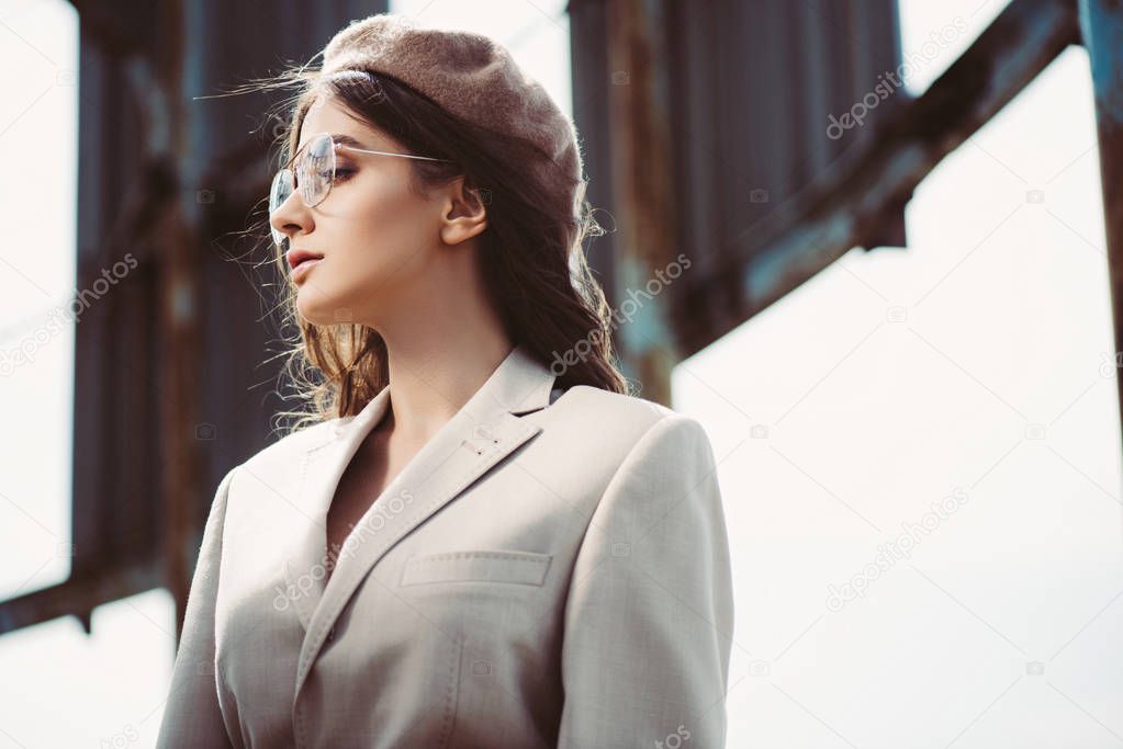 beautiful woman posing in beige suit and trendy beret on roof