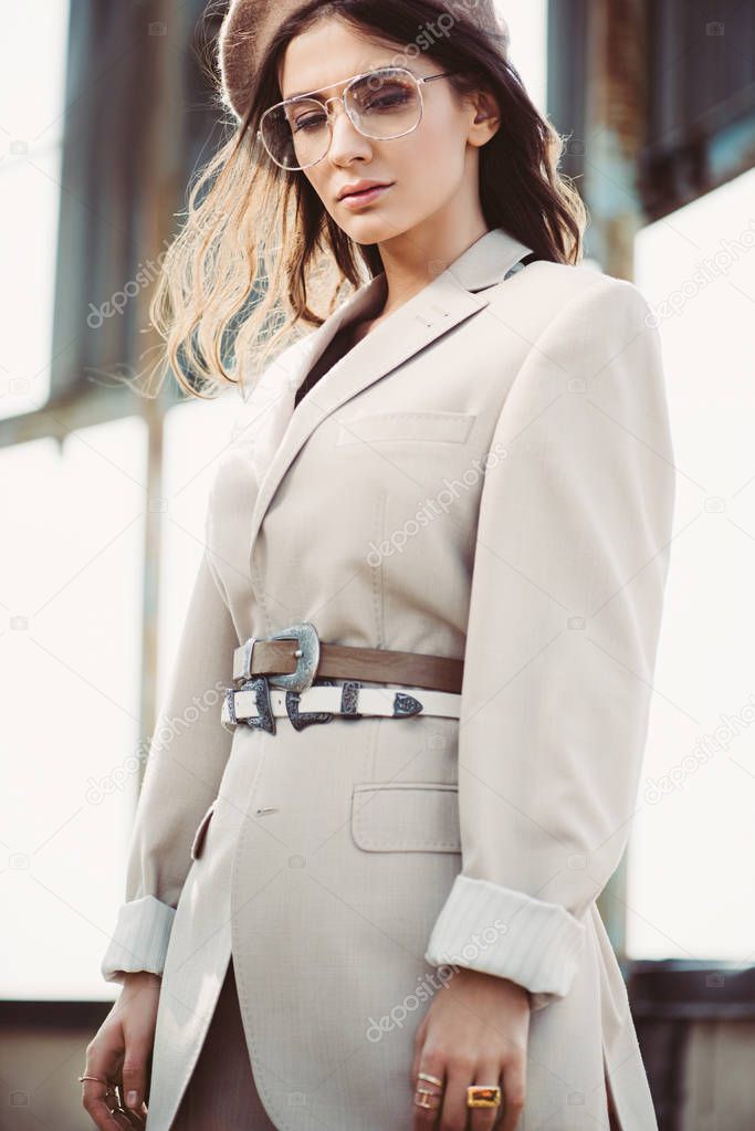fashionable woman posing in beige suit and beret on roof