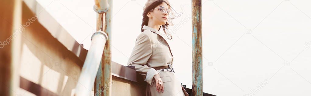 fashionable elegant woman posing in beige suit and beret on roof