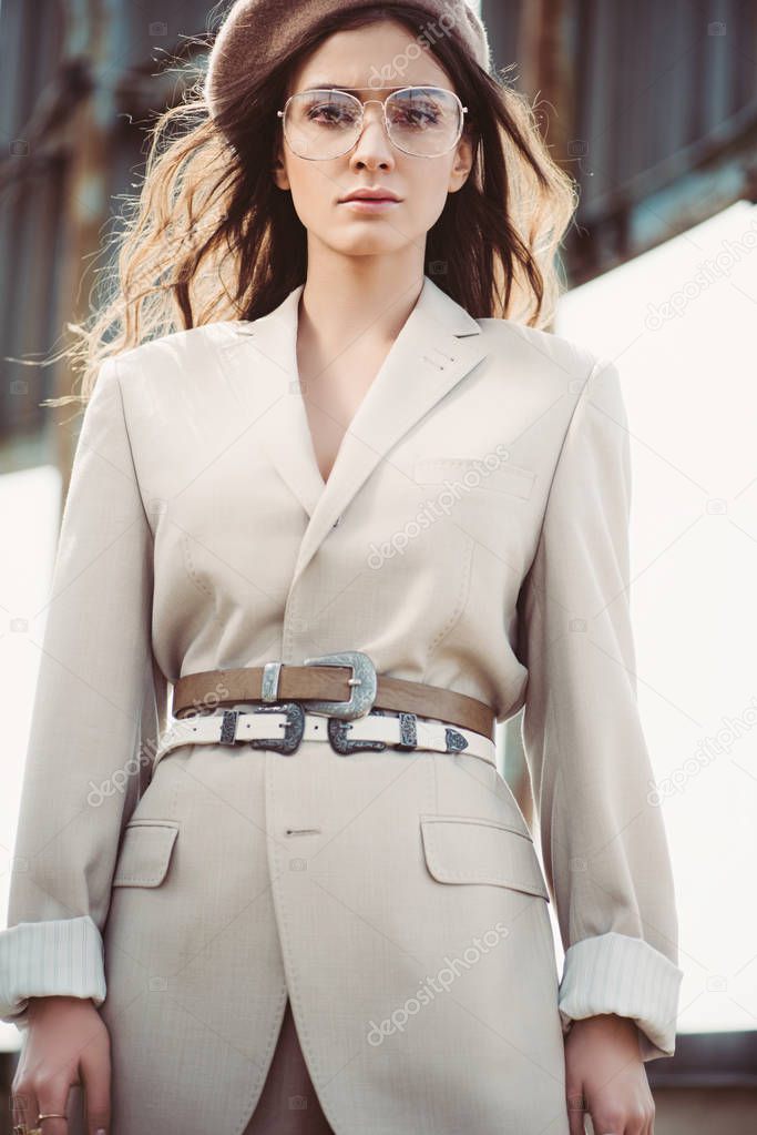 attractive fashionable woman posing in beige suit and beret on roof