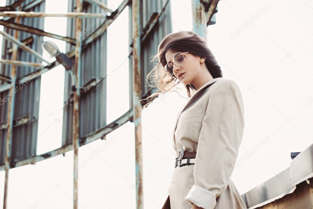 beautiful stylish woman posing in beige suit and beret on roof