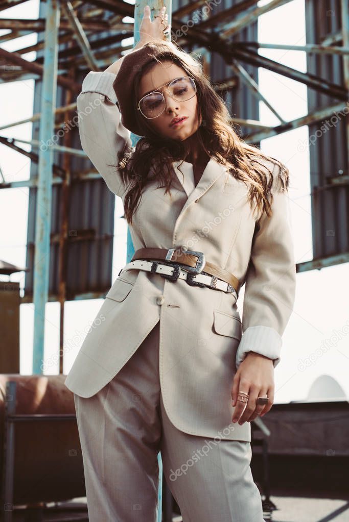 attractive stylish girl modeling in beige suit and beret on roof
