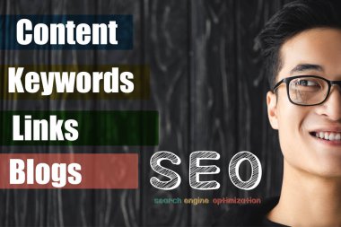 cropped view of smiling asian seo manager looking at illustration with concept words of seo  clipart